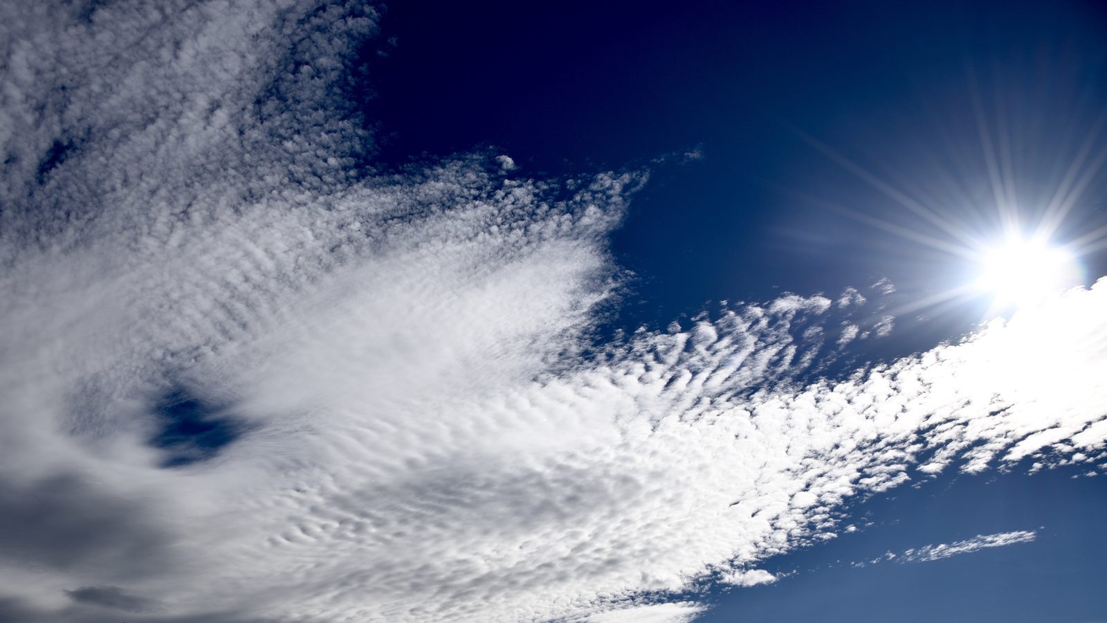Nuvole a pecorelle illuminate dal sole in un cielo blu